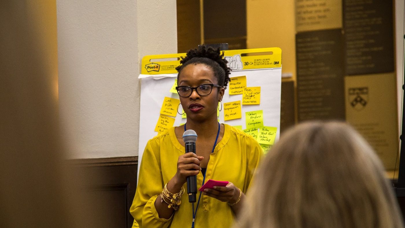 Deidre Osei leading a strategy session, presenting to a room